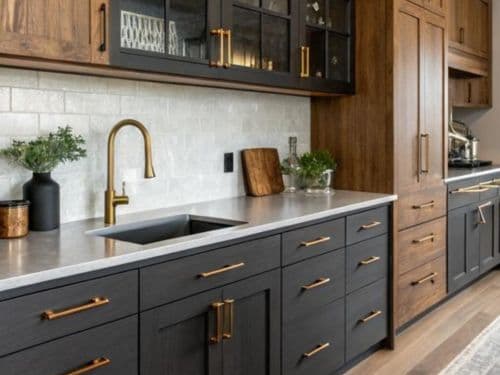 Kitchen with dark lower cabinets, wood upper cabinets and brass fixtures