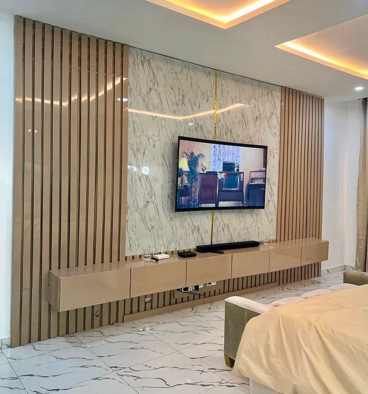 Wood slat and marble-look accent wall behind a wall-mounted TV