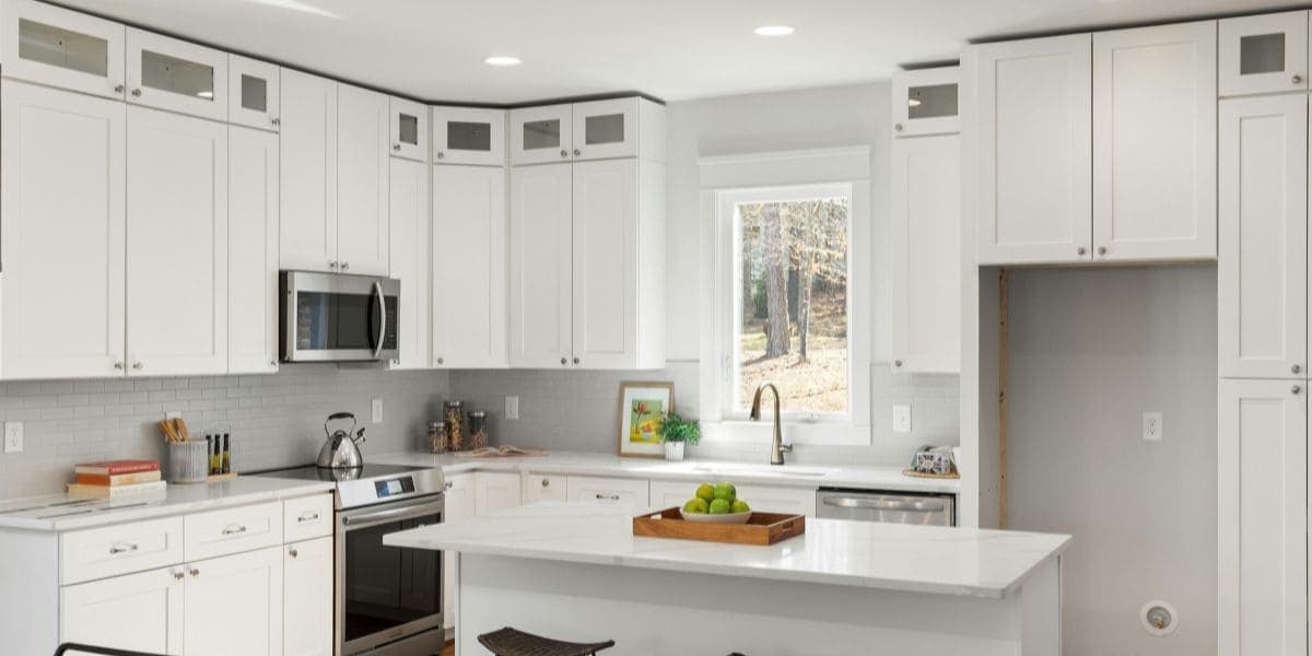White shaker kitchen with island and stainless steel appliances