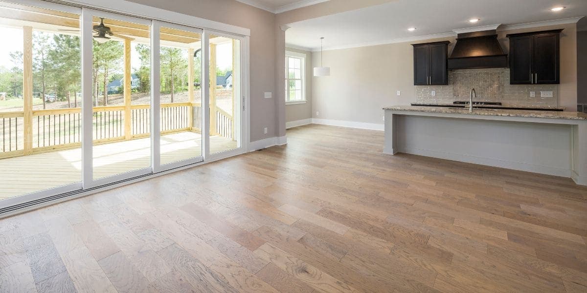 Open living area with new wood-look flooring and sliding doors to the deck
